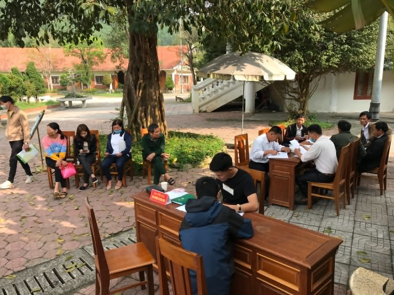 Partners and community members gathered around tables outdoors