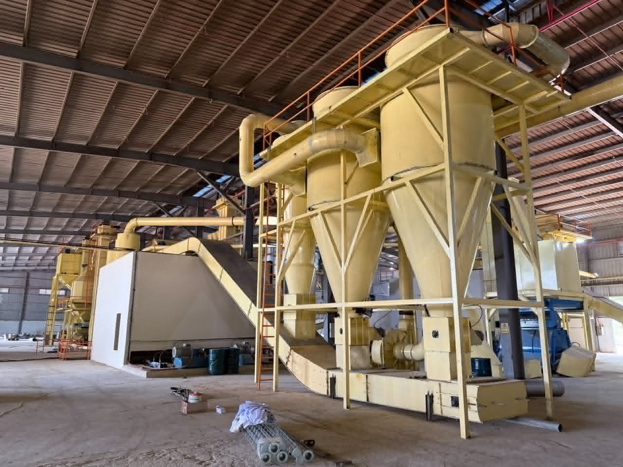 Biomass processing facility with conveyor systems and fuel stockpiles