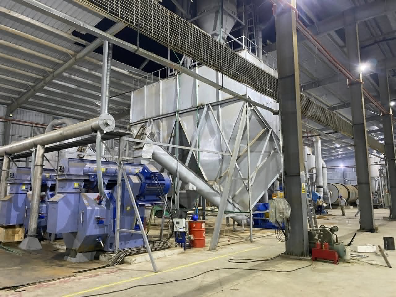 Inside a biomass processing plant with milling equipment and steel ducting
